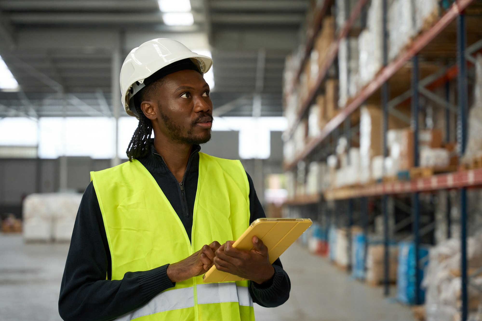 Warehouse worker using digital tablet, managing inventory and logistics